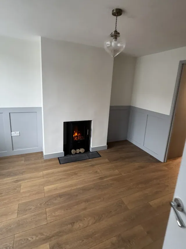 Finished living room with wall panelling and a fireplace feature