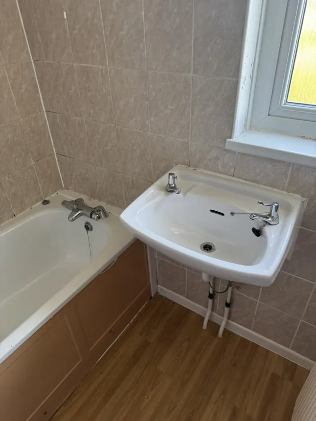 Bathroom with the original bath, basin and tiled walls